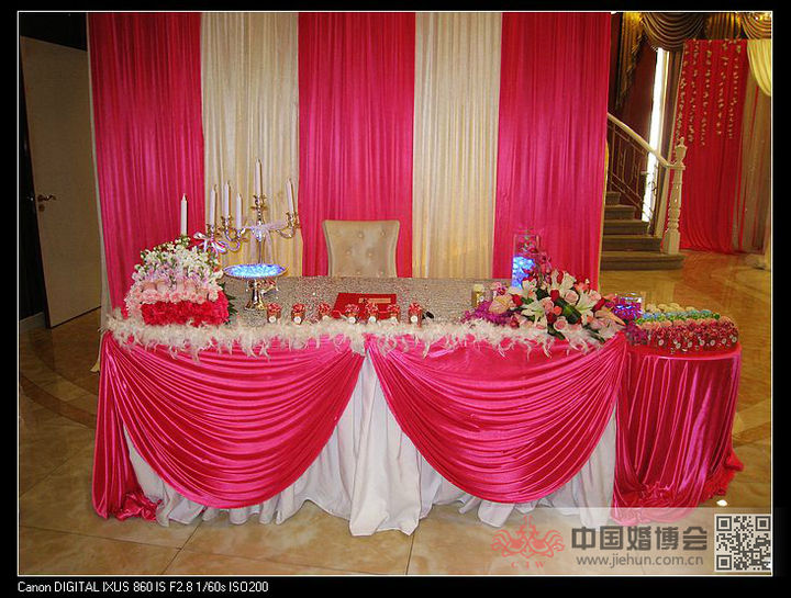 朋友的签到台以红色和粉色为主色调,桌子上放着鲜花和一些像冰块式样